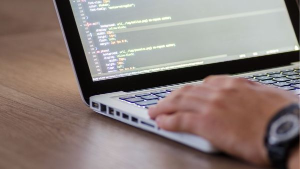 Man working on a laptop coding a website