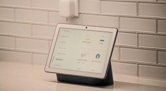 Modern smart home interior with a tablet displaying an energy dashboard and a smart thermostat.